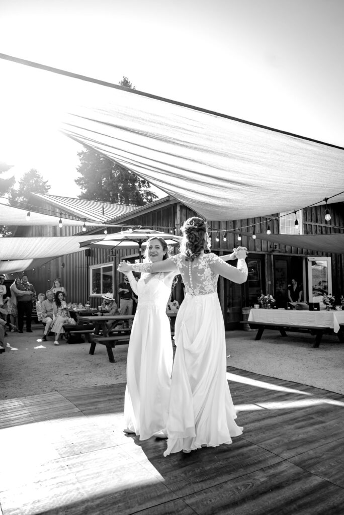 black and white image of two brides dancing and in Eugene oregon